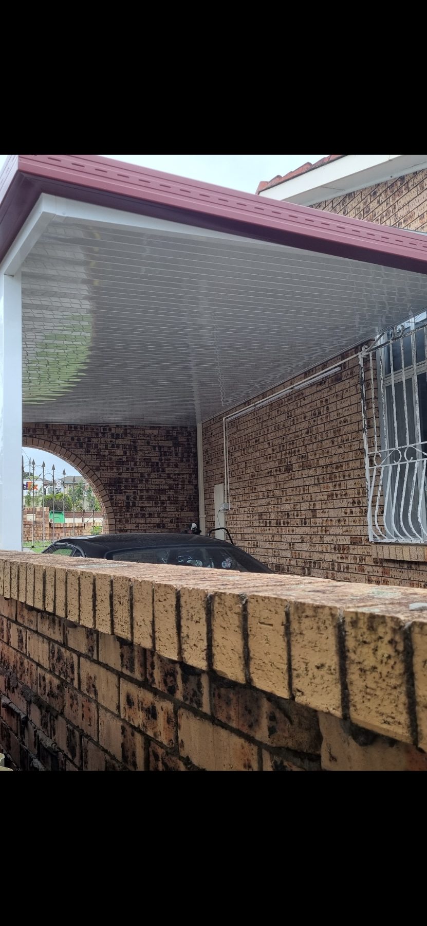 Carport attached to a brick wall