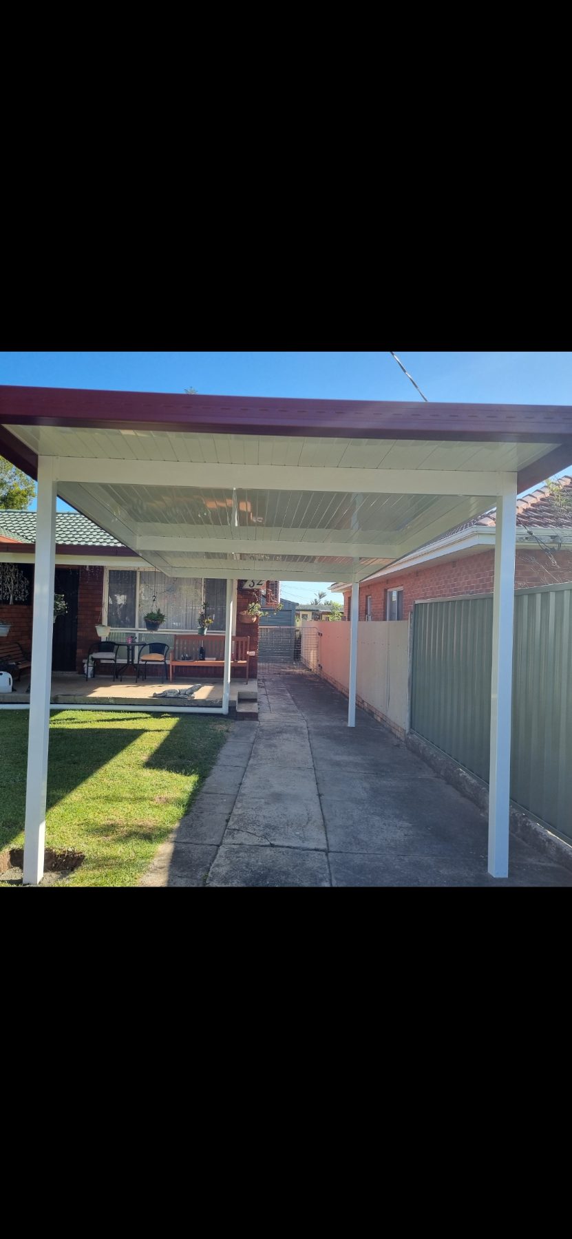 Attached carport alongside a brick home